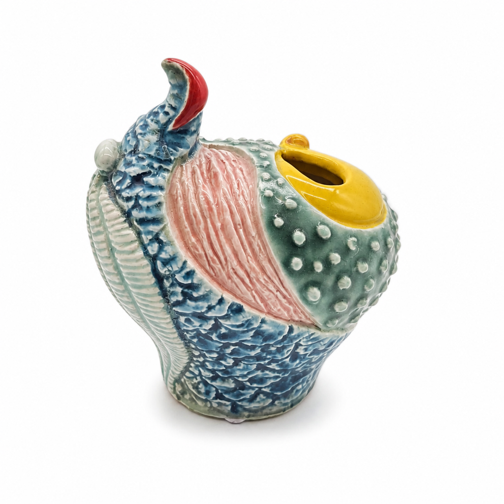 Abstract whale-inspired ceramic relief on a clean white studio background
